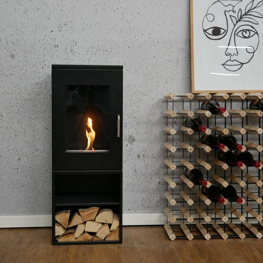 Cheyenne bioethanol stove fireplace with firewood in the storage compartment, lit flame, styled living space with concrete wall and wine rack