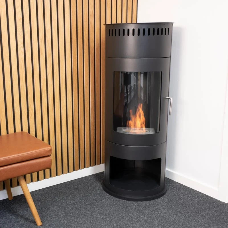 Washington black bioethanol stove lit in a showroom corner with a wood slat wall, different angle